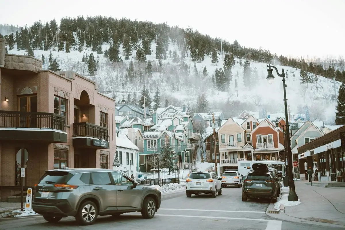 Charming winter street with colorful houses and cars in Park City, Utah.