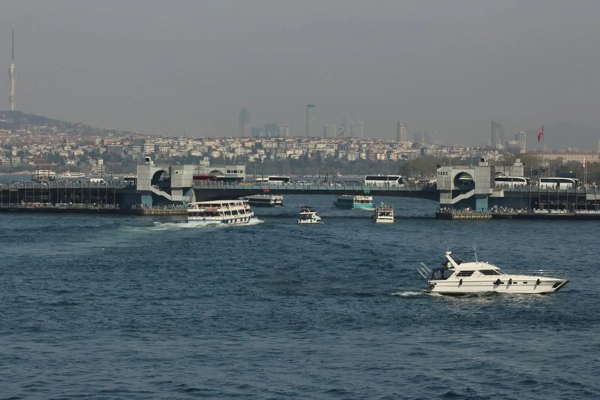 A scenic view of boats in Istanbul's Bosphorus Strait, showcasing urban landscape and city skyline.