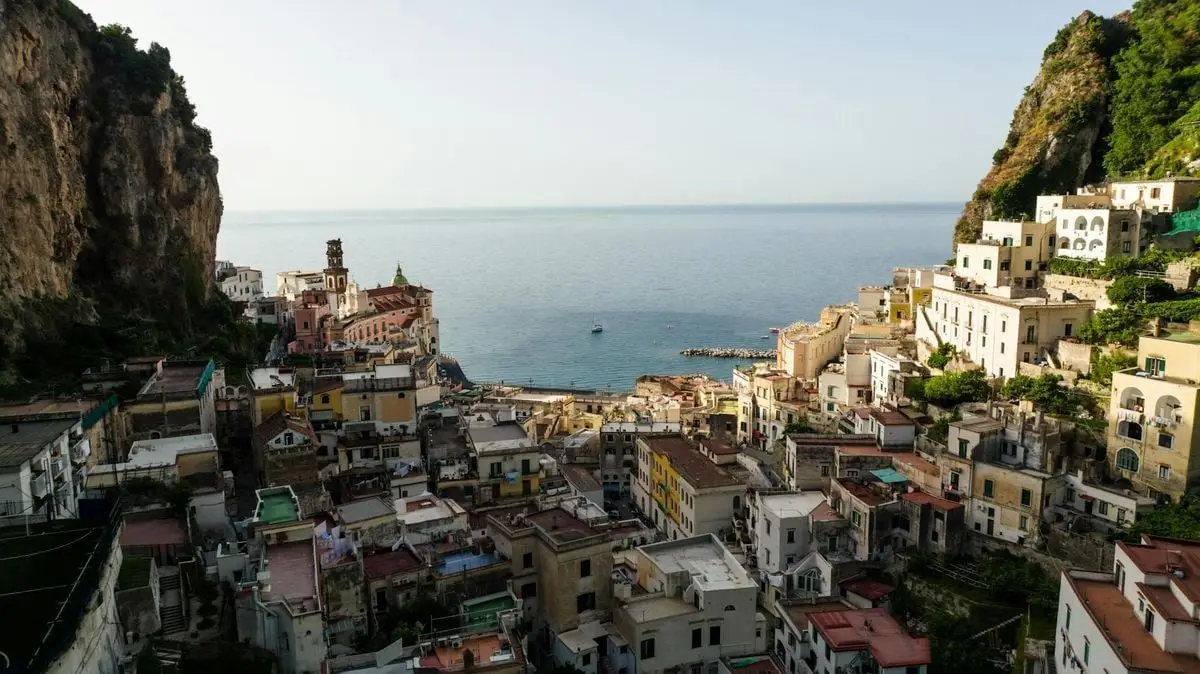 A picturesque view of an Italian coastal town with colorful buildings and a calm sea.