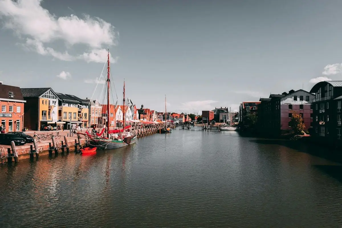 Charming harbor scene in Husum, showcasing vibrant buildings and docked boats.
