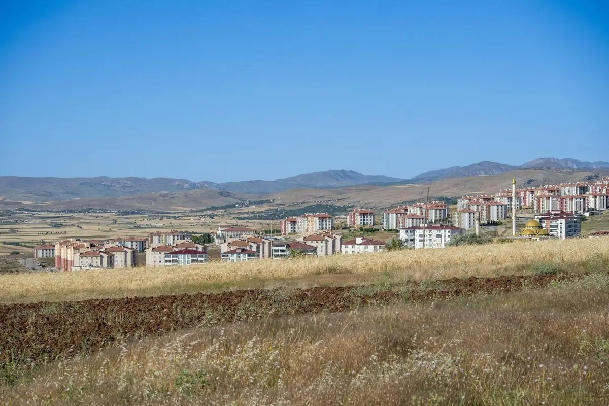 Expansive view of Palu, Elazığ showcasing modern housing against scenic mountain backdrop.