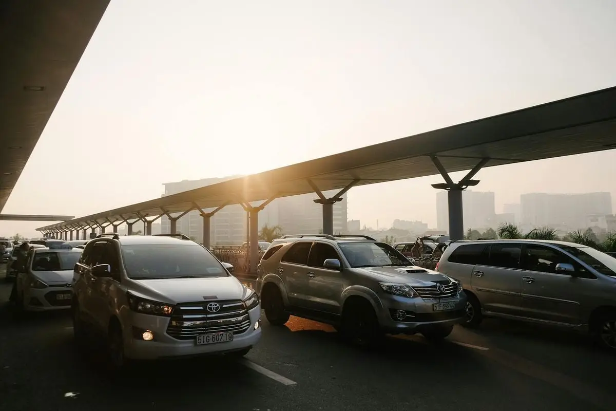 Busy city traffic during sunrise with skyline in the background, showcasing urban life.