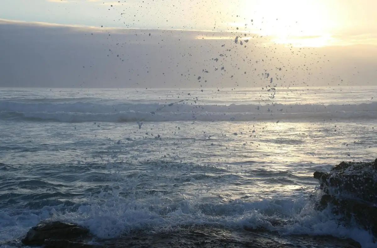 Captivating view of ocean waves splashing at sunrise, creating a serene seascape.