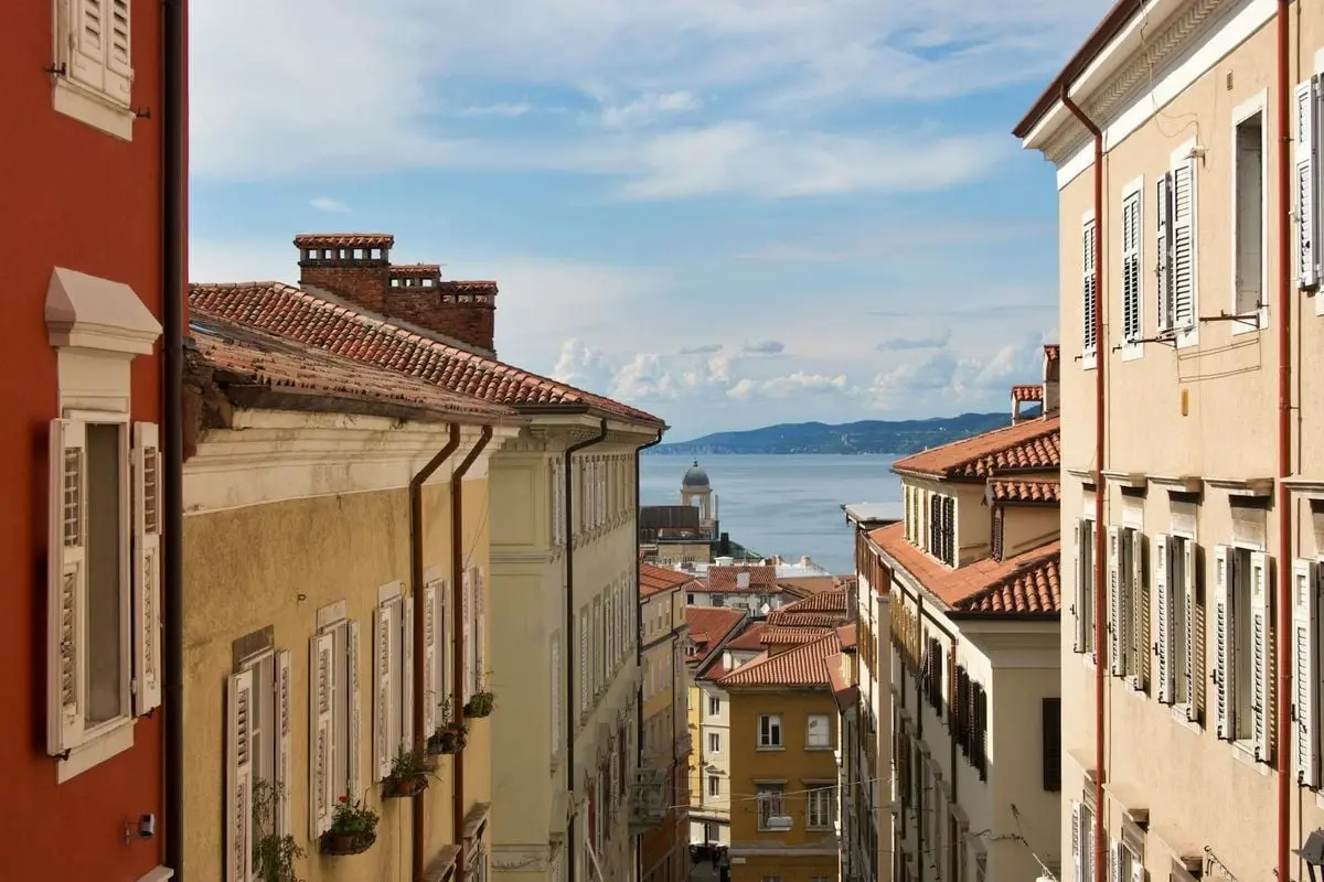 Scenic view of an Italian coastal town with colorful buildings and sea backdrop.