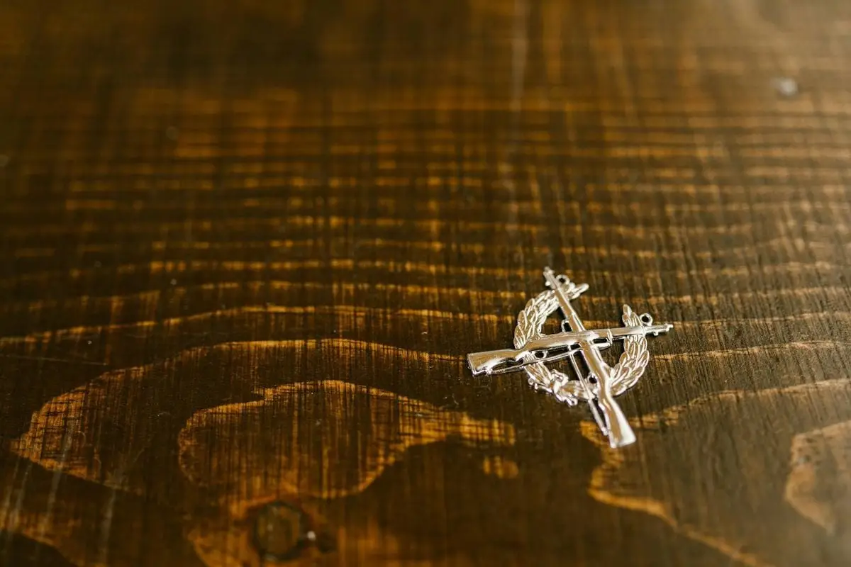 Close-up of a military medal placed on a textured wooden surface, symbolizing honor.