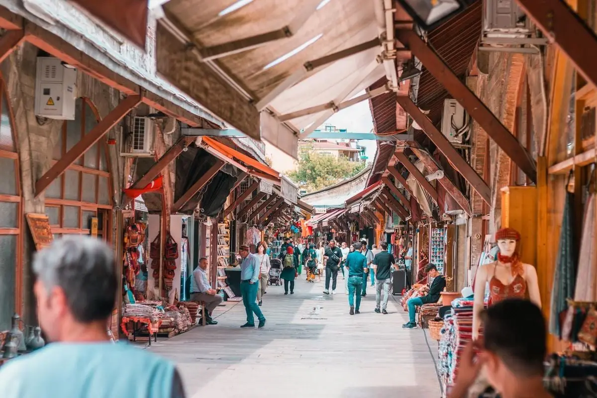 Explore the bustling atmosphere of a Turkish street market in Istanbul with people and shops.