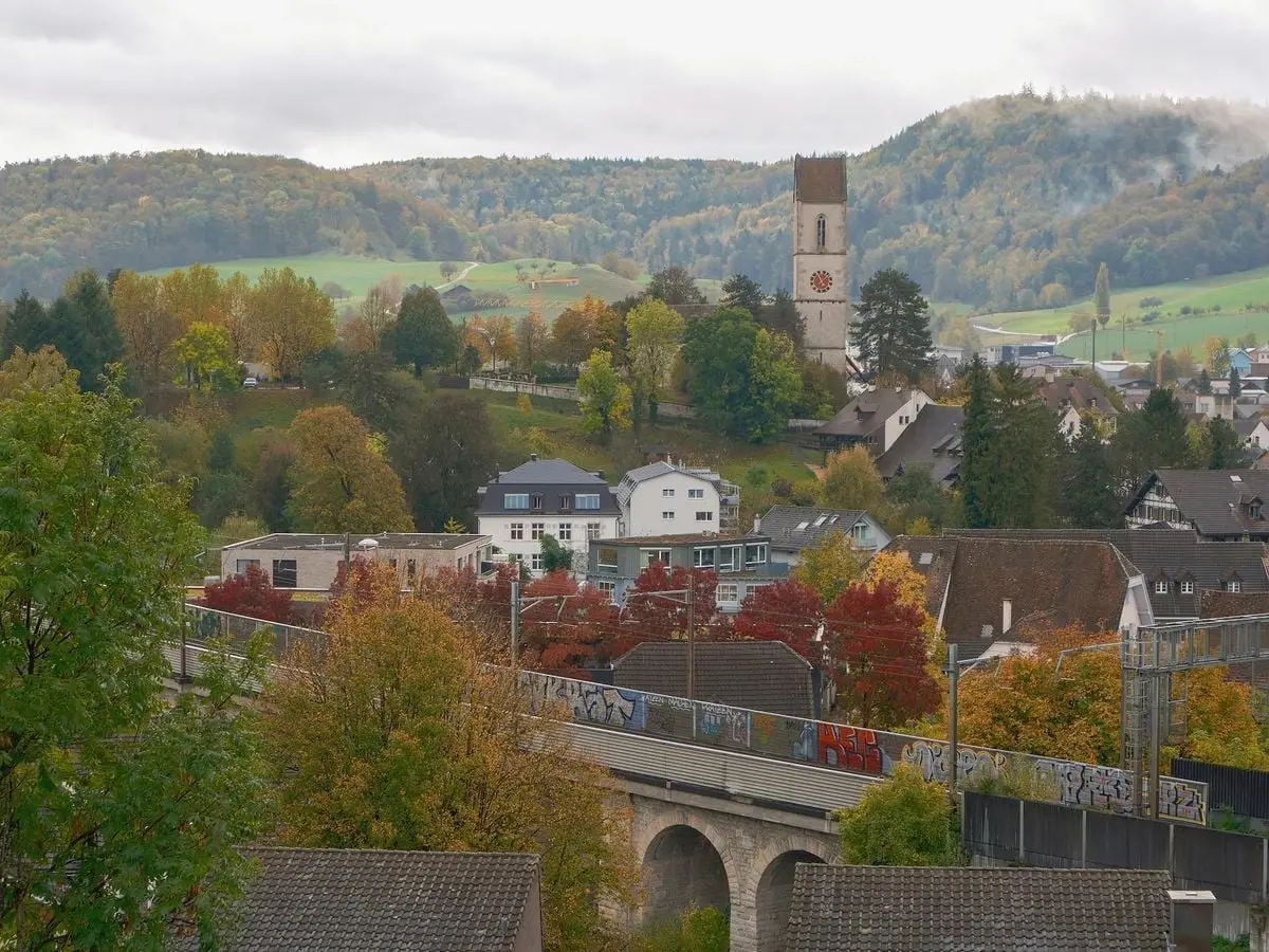 Charming small town in a vibrant autumn setting with colorful foliage and hills.