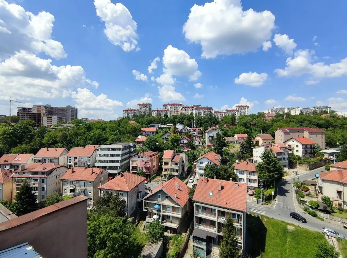 Aerial view showcasing a quiet suburban neighborhood with red-tiled roofs and lush greenery.