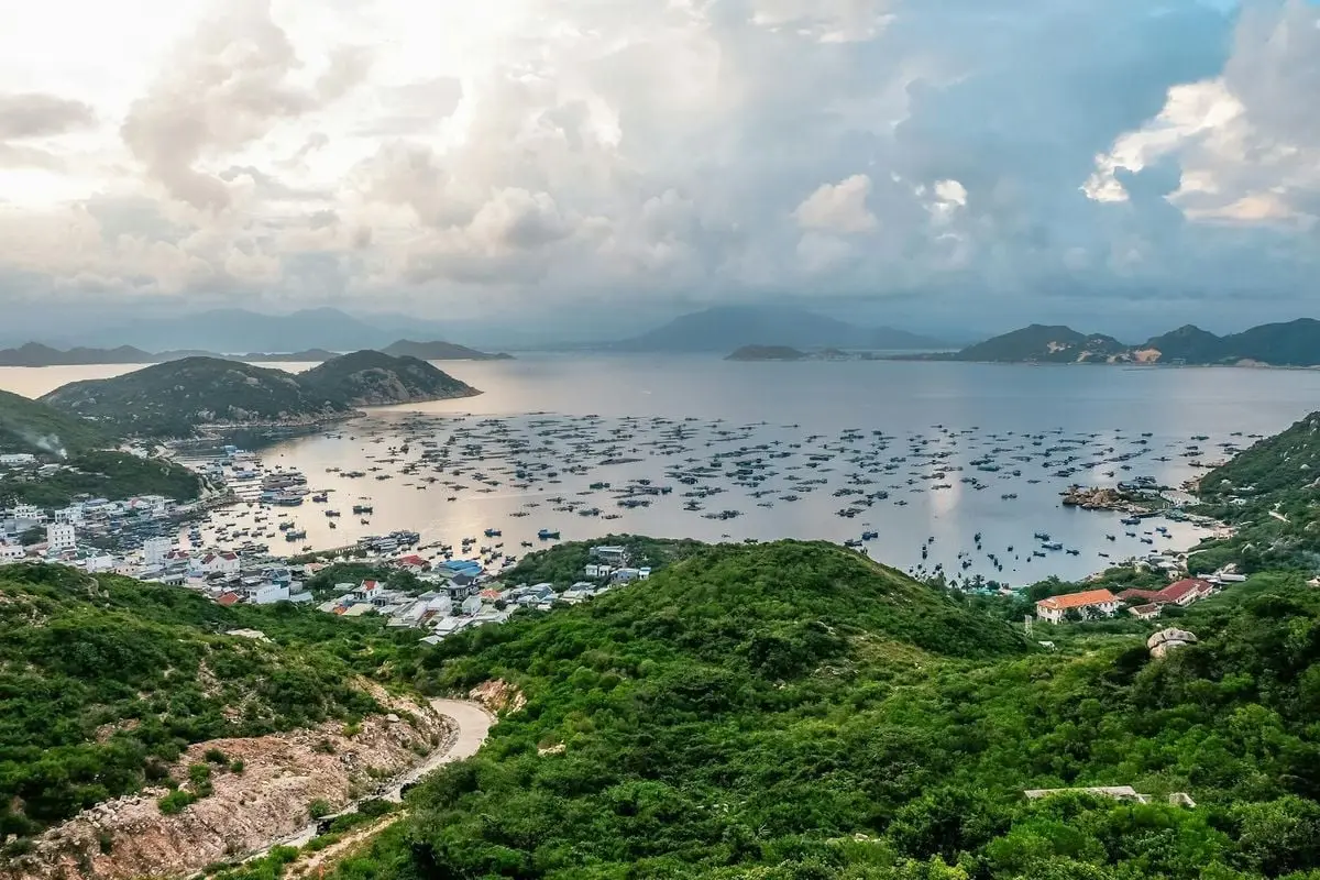 A breathtaking aerial view of a bustling coastal town with a picturesque harbor and lush greenery.