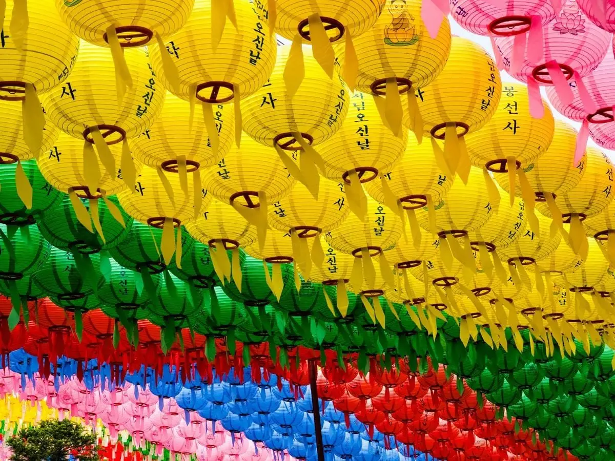 Colorful lanterns with Korean script hanging in rows, creating a vibrant festive atmosphere.