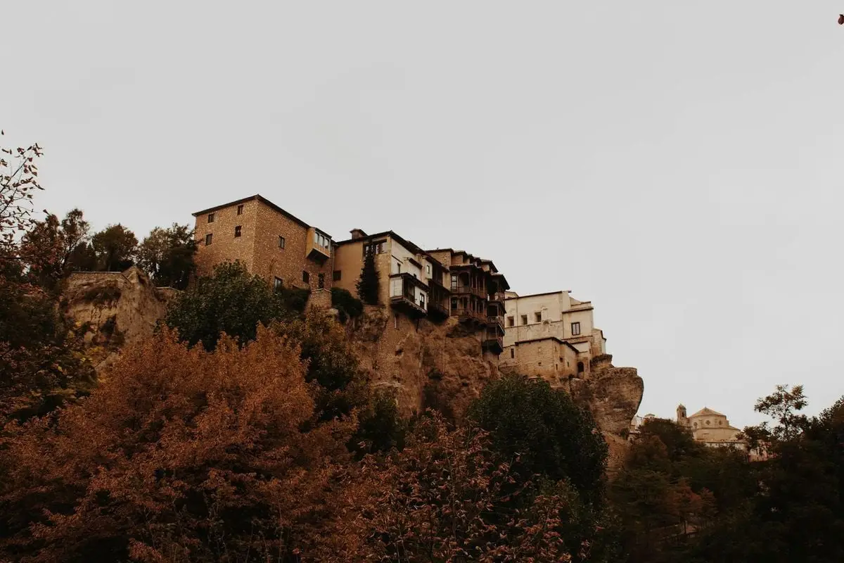 Stunning view of the historic Hanging Houses perched on a cliff in Cuenca, Spain during fall.