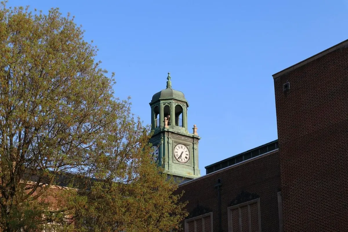A beautiful view of a historic clock tower with clear blue sky and surrounding buildings.