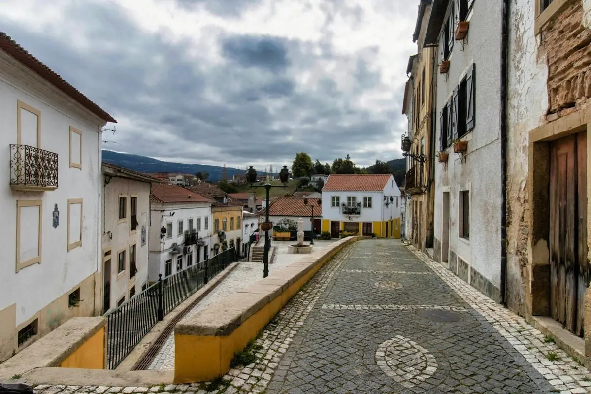 Charming cobblestone street in Miranda do Corvo, Portugal, with traditional architecture.