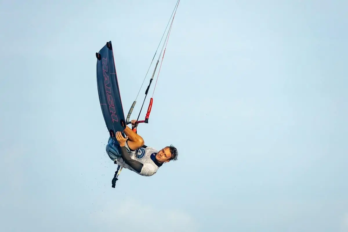 Thrilling kitesurfing trick performed midair, showcasing skill and adrenaline.