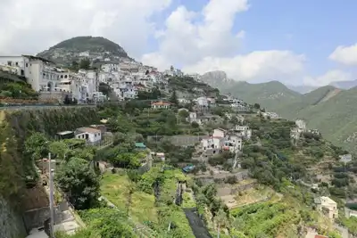 Scenic view of a charming town nestled on the hills of the Amalfi Coast with lush greenery.