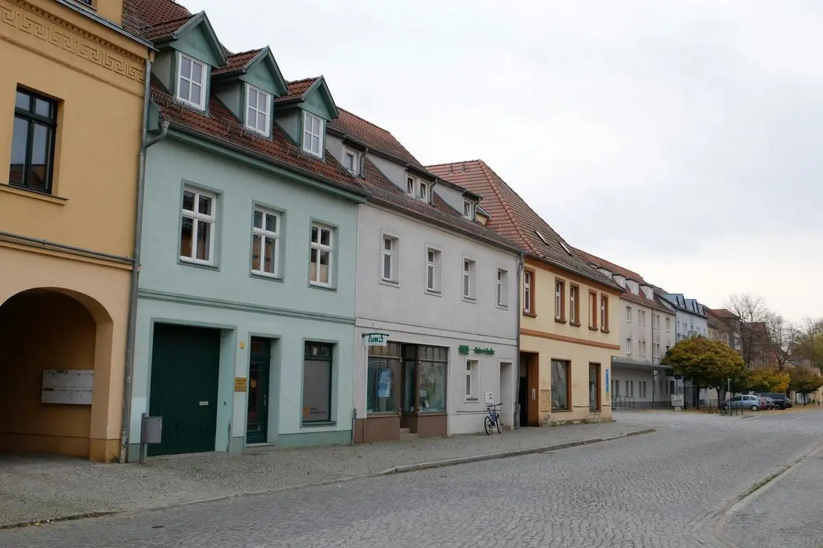 A picturesque European street lined with pastel-colored buildings and a cobblestone road.