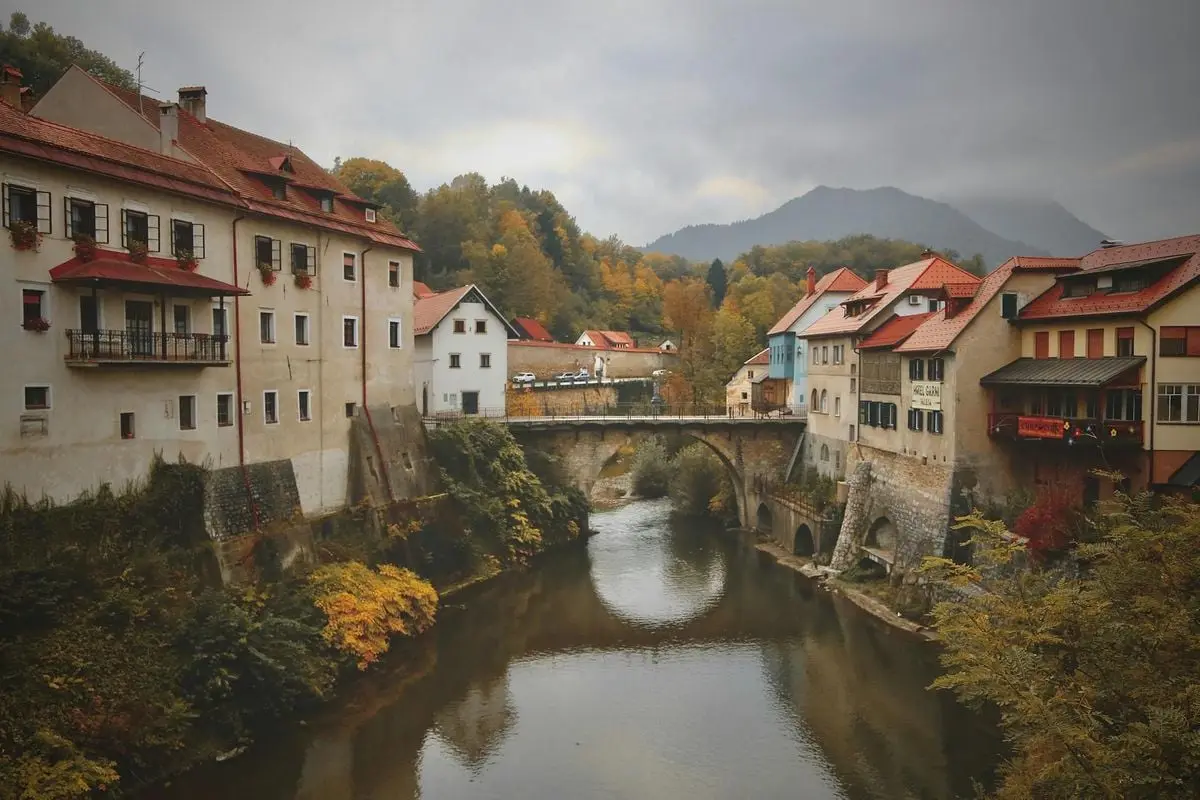 Beautiful autumn landscape of Škofja Loka with historic buildings and a river.