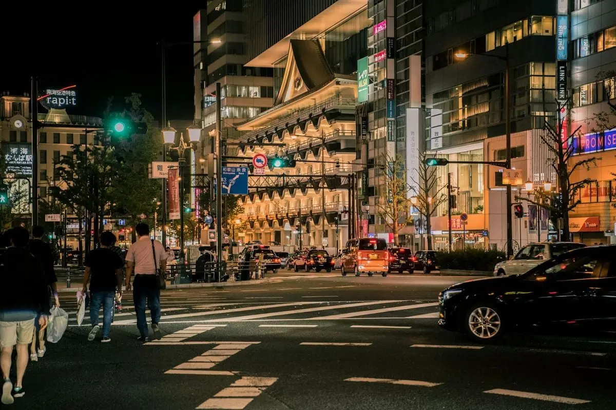Illuminated cityscape in Osaka, Japan featuring modern architecture and bustling streets at night.