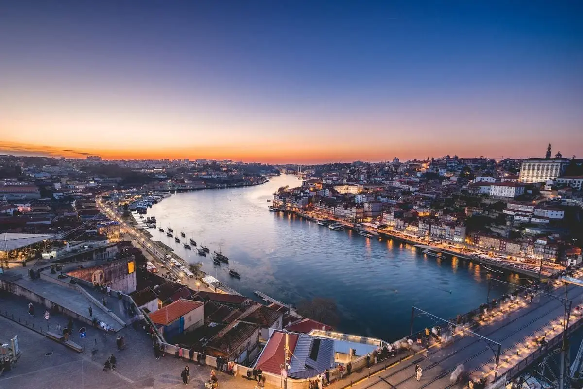 A stunning sunset view of Porto's urban landscape and the Douro River, capturing the city's vibrant atmosphere.