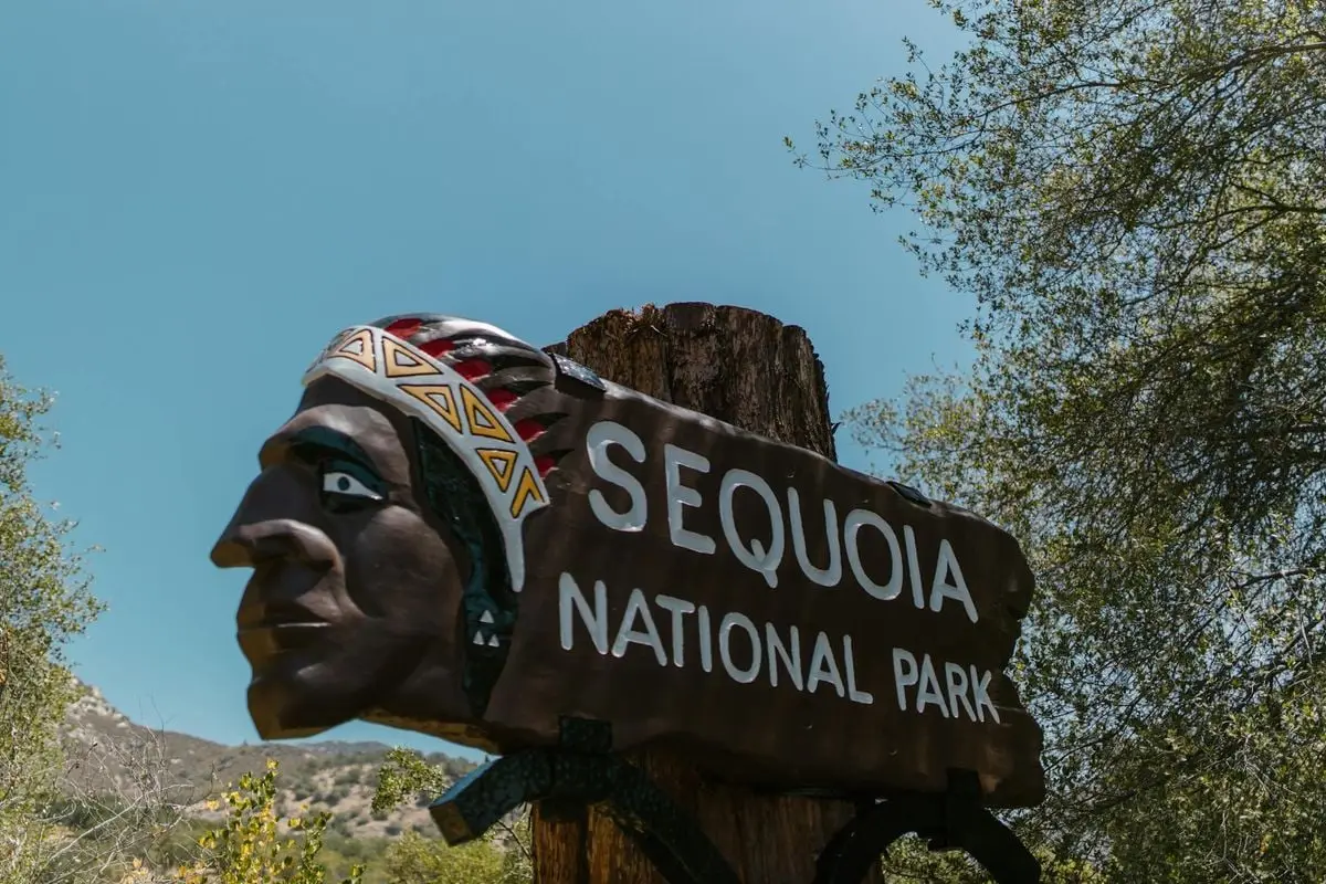 Close-up of Sequoia National Park entrance sign featuring a Native American motif.