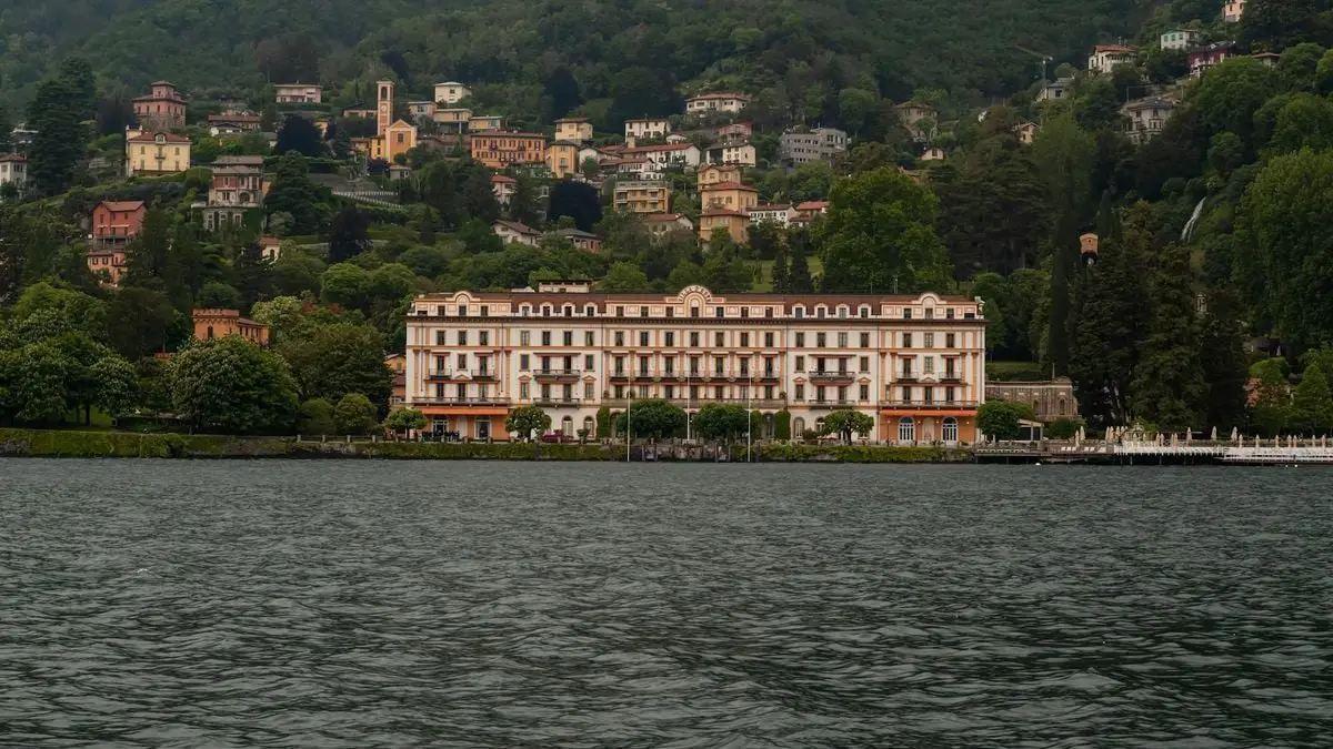 Stunning lakefront view of historic architecture in Como, Lombardy, Italy with lush hills.