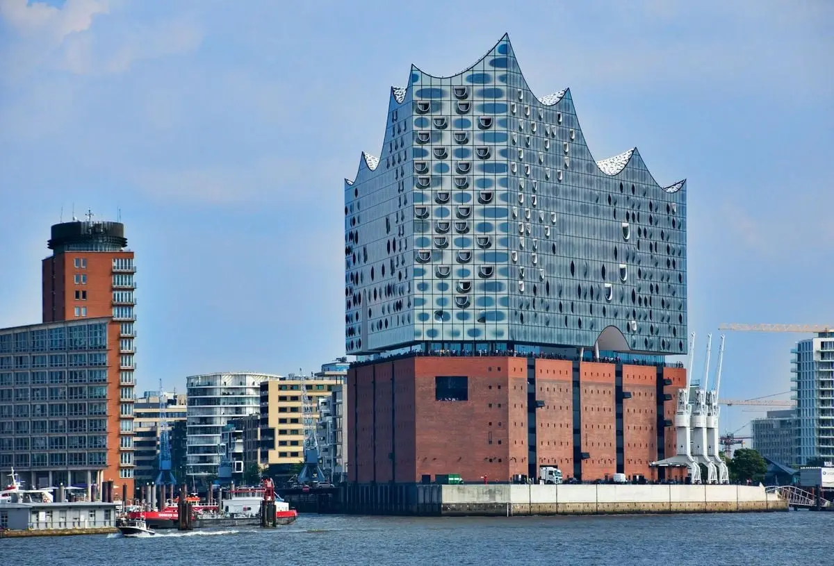 Modern architectural masterpiece, Elbphilharmonie in Hamburg, by the river with skyline.