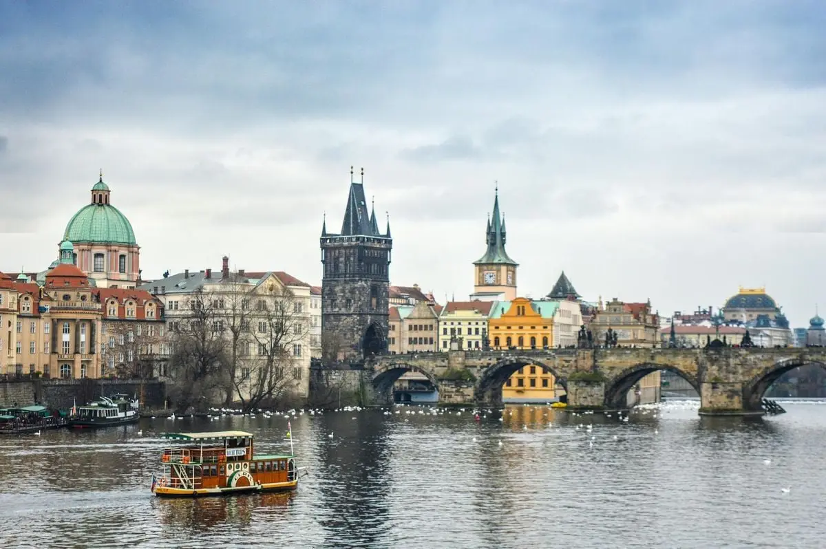 A picturesque view of the historic Charles Bridge and surrounding architecture in Prague over the Vltava River.