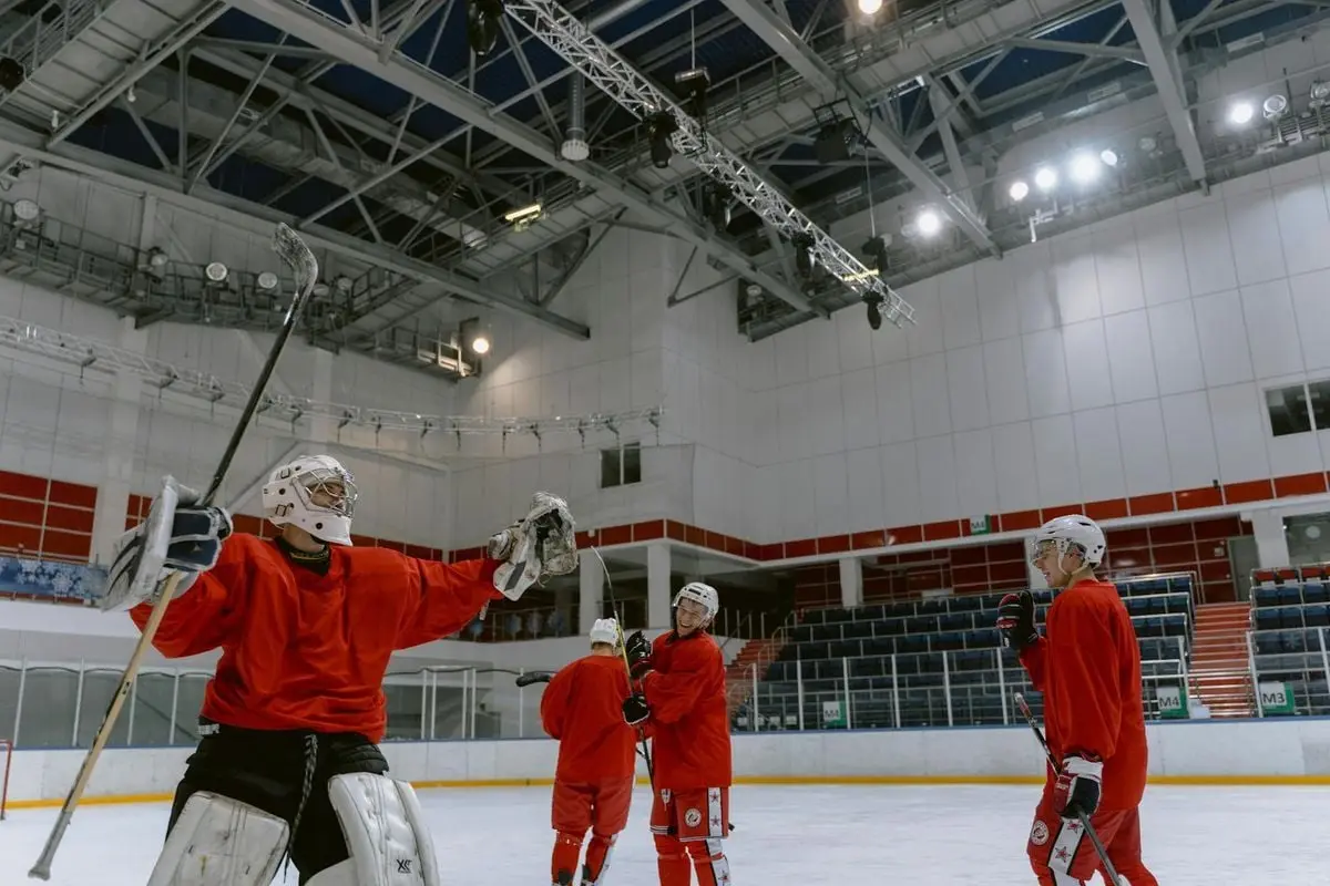Hockey players practicing teamwork and skills on an indoor ice rink.