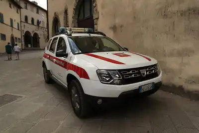 Municipal Police SUV parked in a quaint Italian town square, showcasing local architecture.