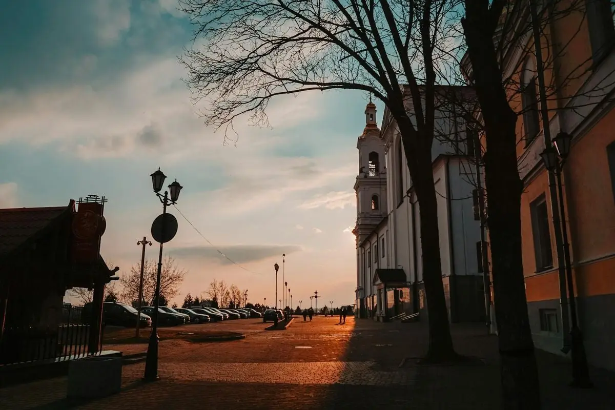 A stunning sunset over a historic church and street in Vitebsk, Belarus, capturing urban tranquility.