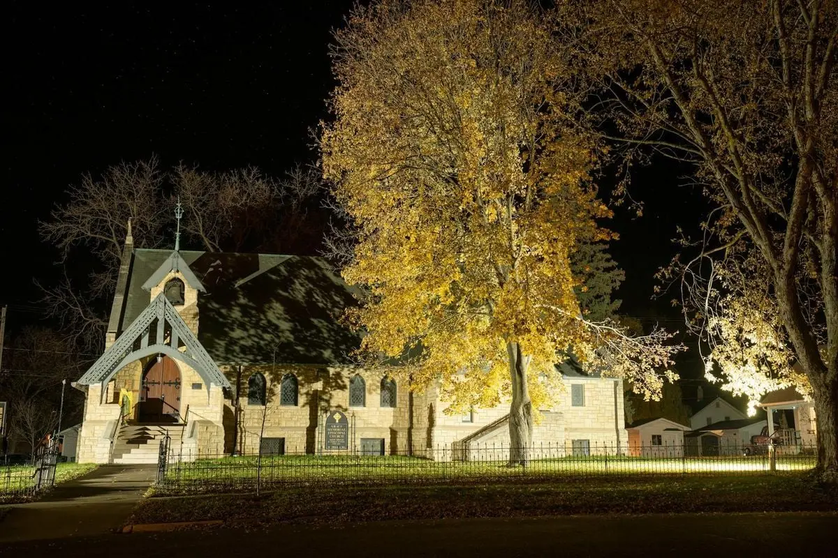 A beautifully lit church in Wabasha, MN, showcasing classic architecture against a night sky.