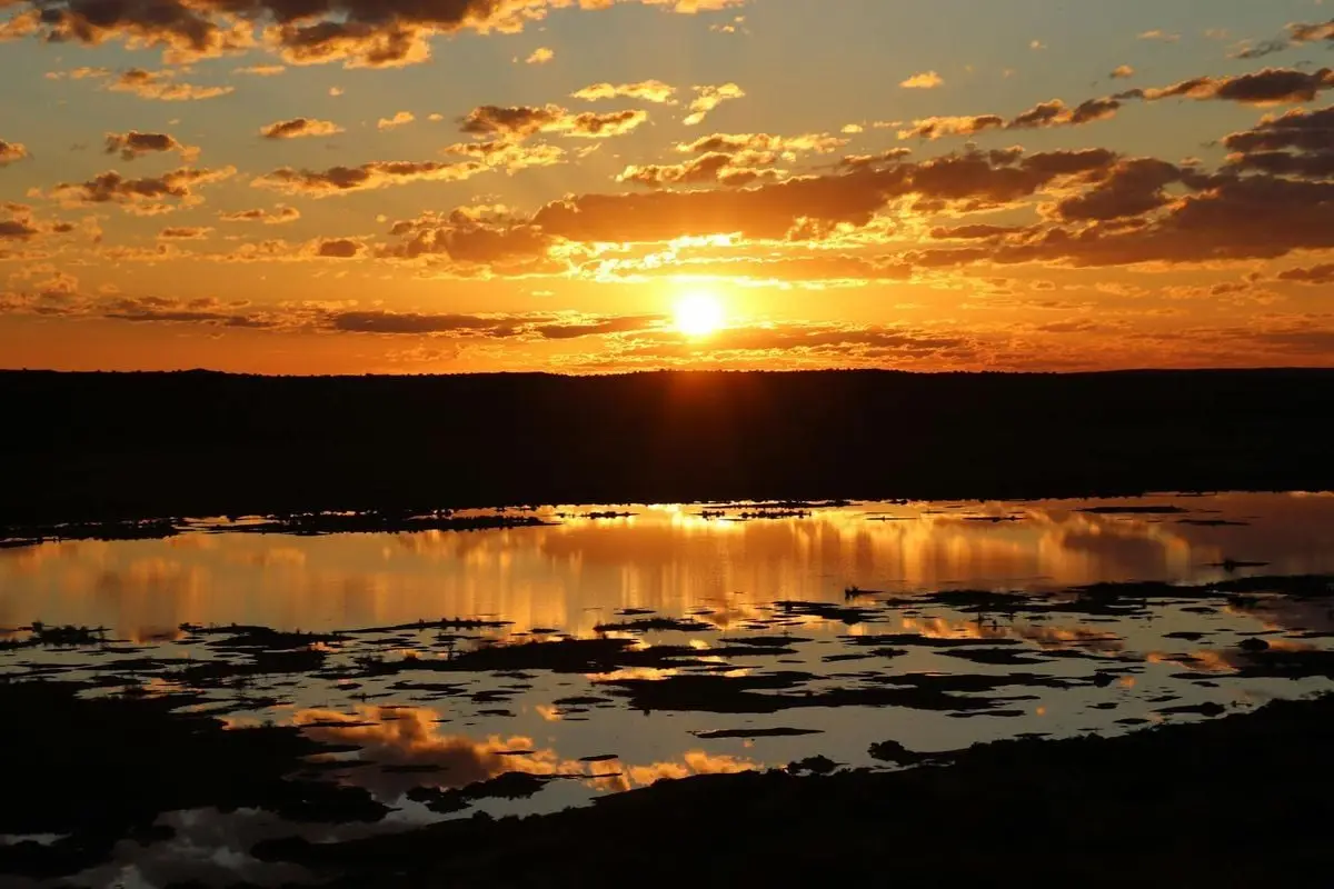 Beautiful sunset reflecting over a serene desert water body in Australia.