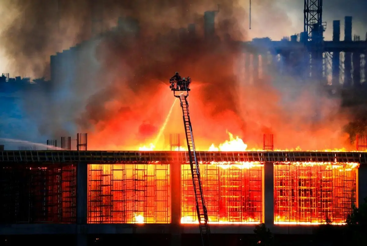 Firefighters battle a large building fire at night, showcasing bravery and emergency response.
