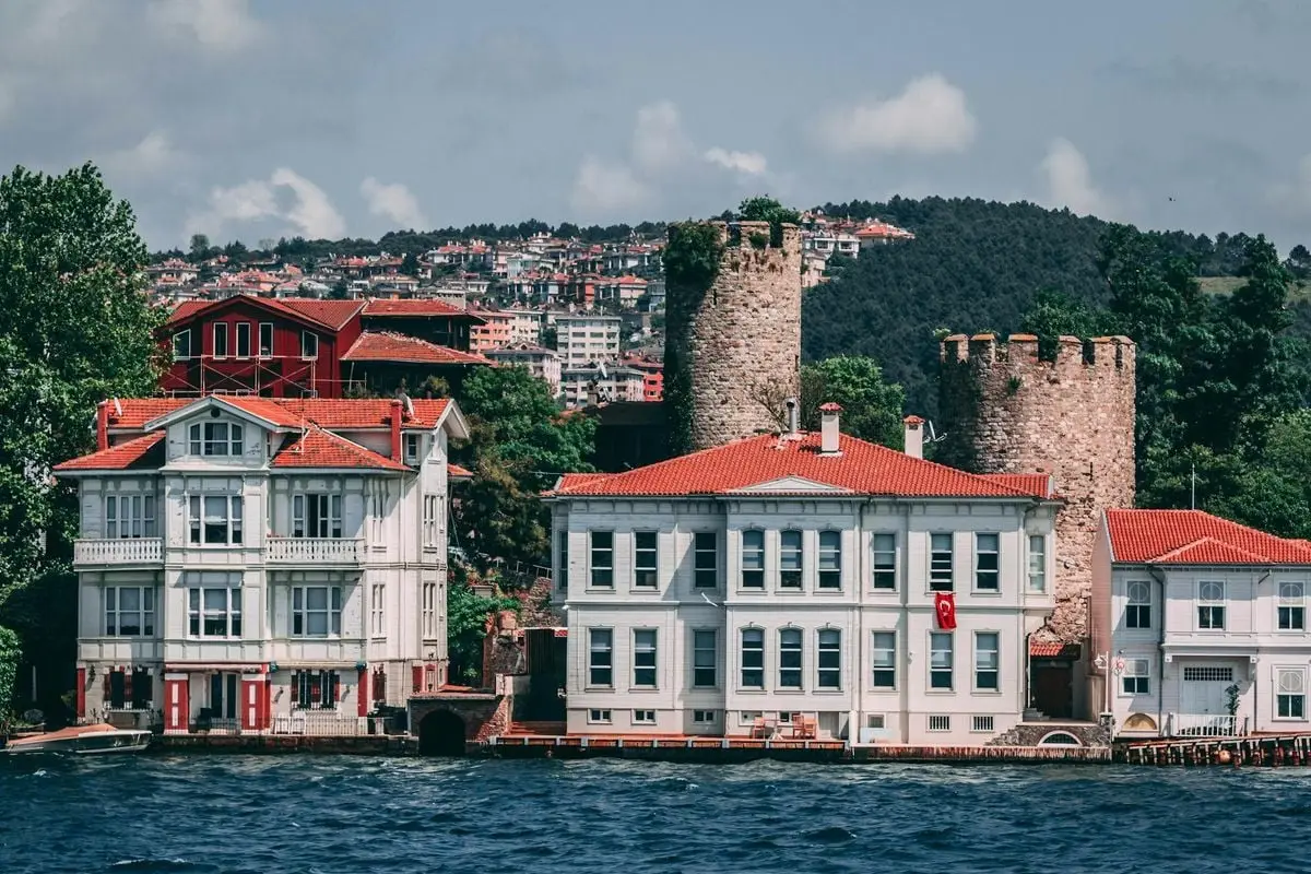 Charming waterfront architecture featuring historical stone towers and vibrant red rooftops by the sea.