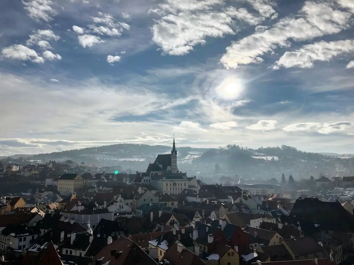 Capture of Český Krumlov's historic rooftops under a bright winter sky.