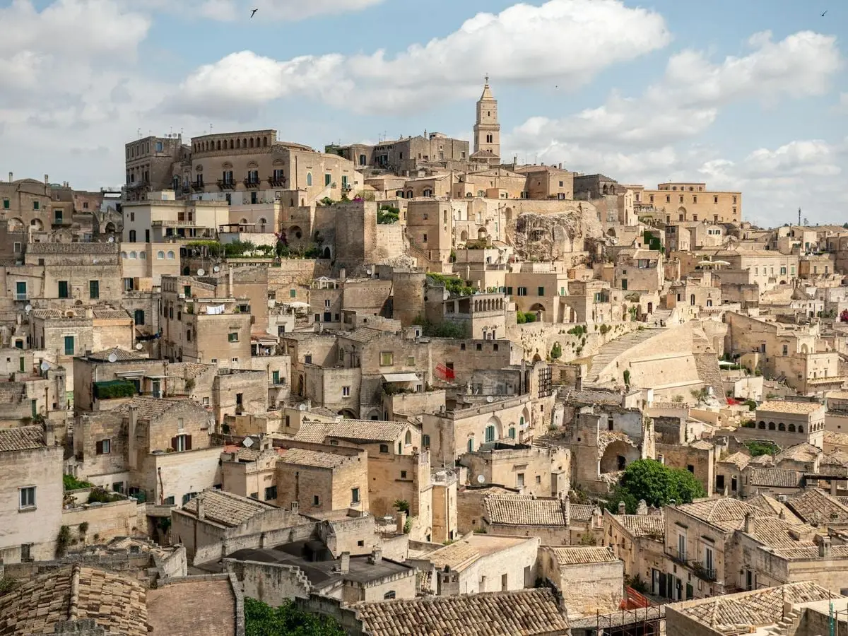 Scenic view of Matera's ancient stone dwellings under a blue sky.