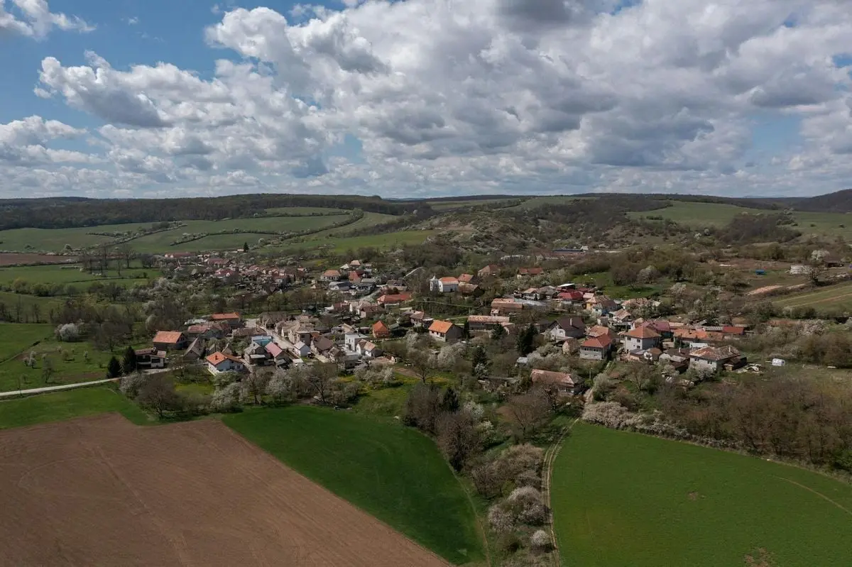 Stunning aerial view of Bretka village in Slovakia, surrounded by lush farmlands under a bright summer sky.