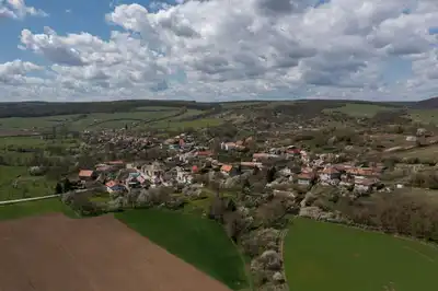 Stunning aerial view of Bretka village in Slovakia, surrounded by lush farmlands under a bright summer sky.