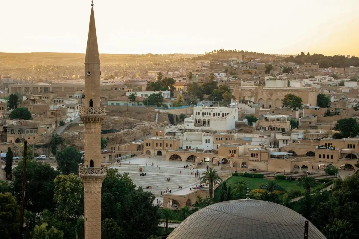 Stunning aerial view of a mosque minaret in Şanlıurfa, Turkey, capturing urban charm and Islamic architecture.