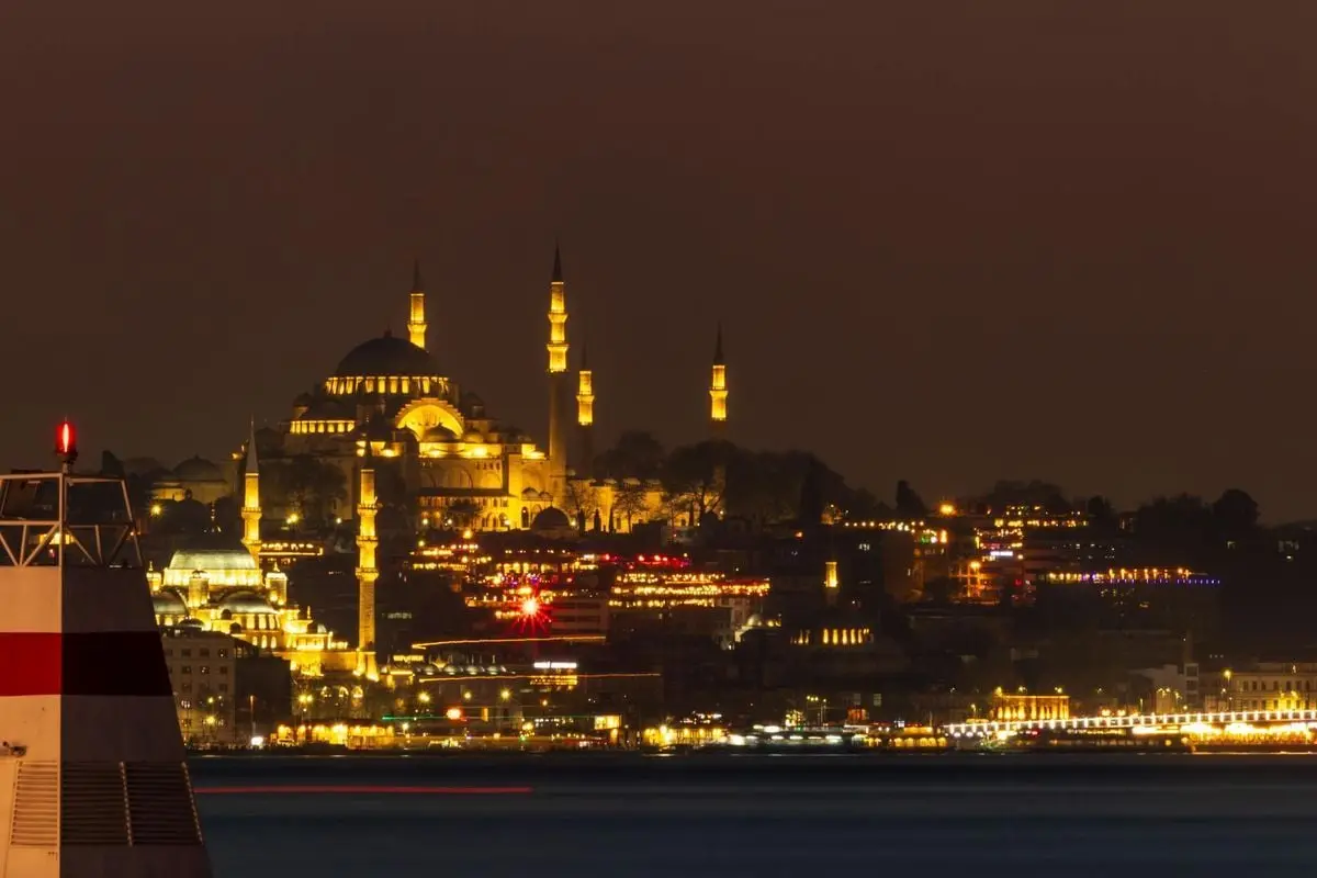 Enchanting night view of Istanbul's iconic Suleymaniye Mosque, beautifully lit with a cityscape backdrop.