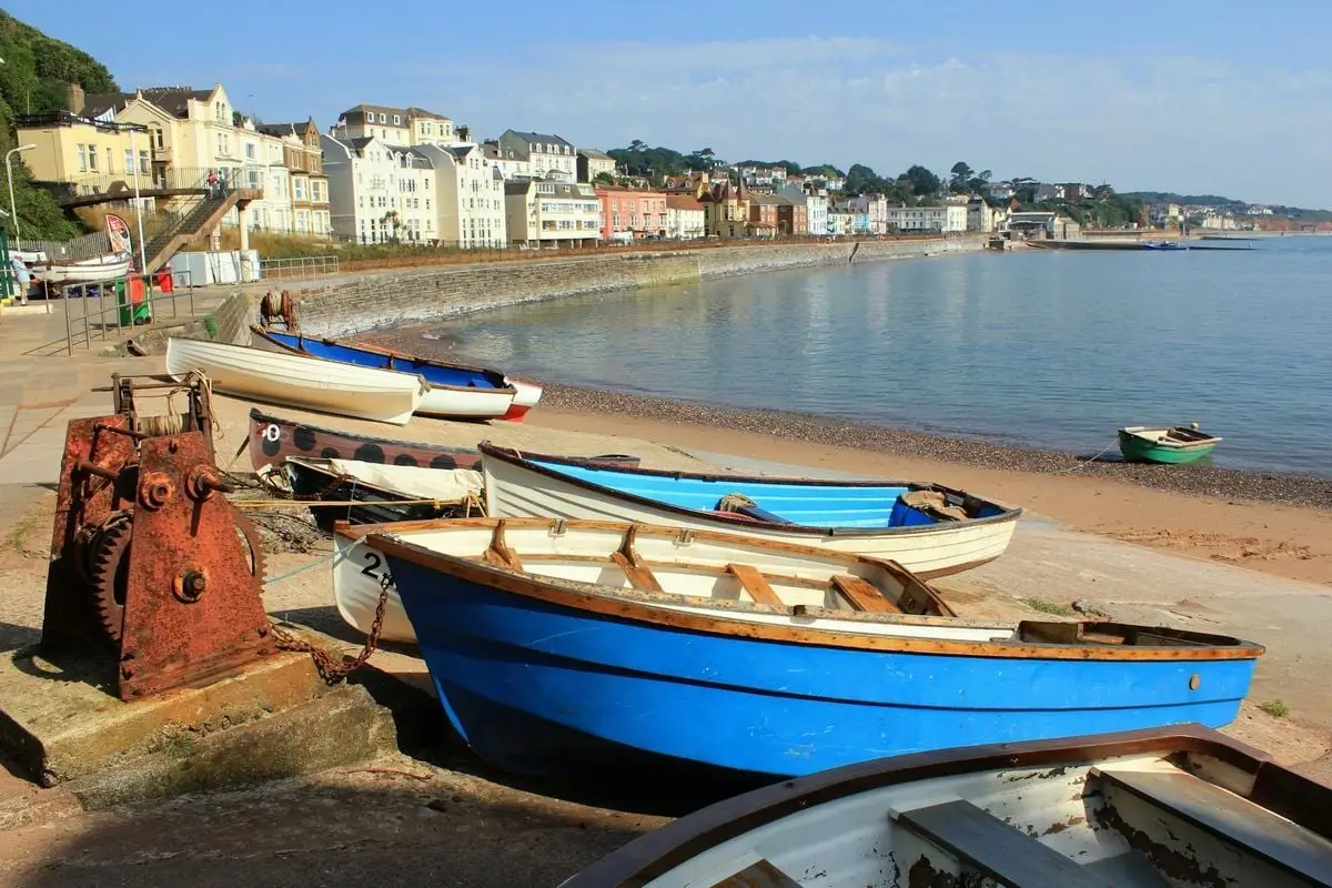 A picturesque coastal town with rowboats on the sandy shoreline, perfect for travel and seaside exploration.
