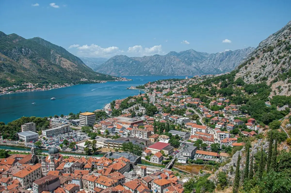 A breathtaking aerial view of Kotor Bay with its scenic mountains, vibrant town, and deep blue sea in Montenegro.