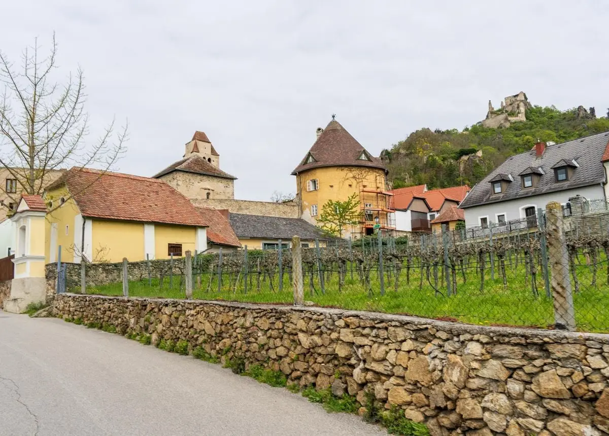 Scenic spring view of a quaint Dürnstein village street lined with historic buildings.