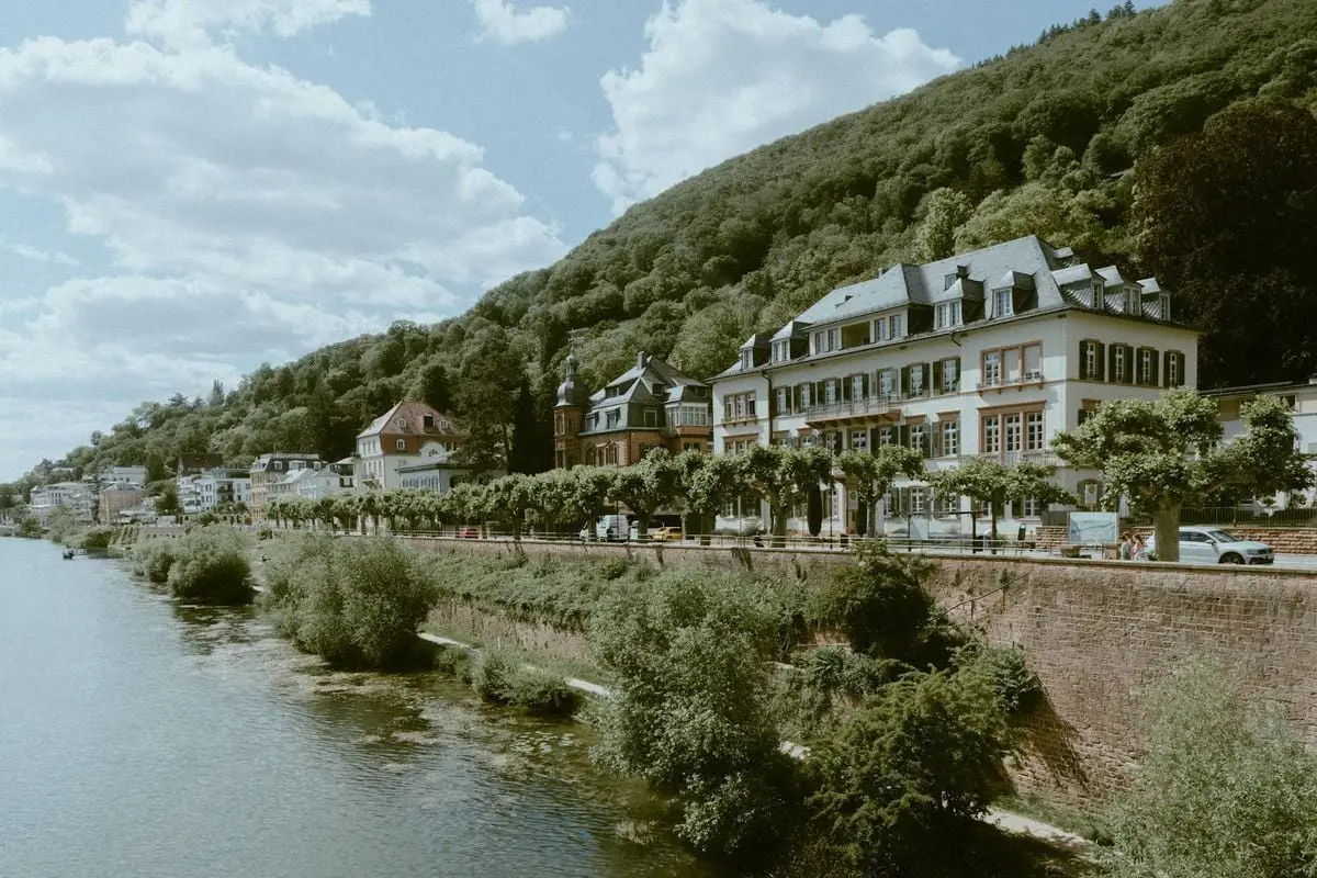 Charming hillside town in Europe with historic architecture along a peaceful river.
