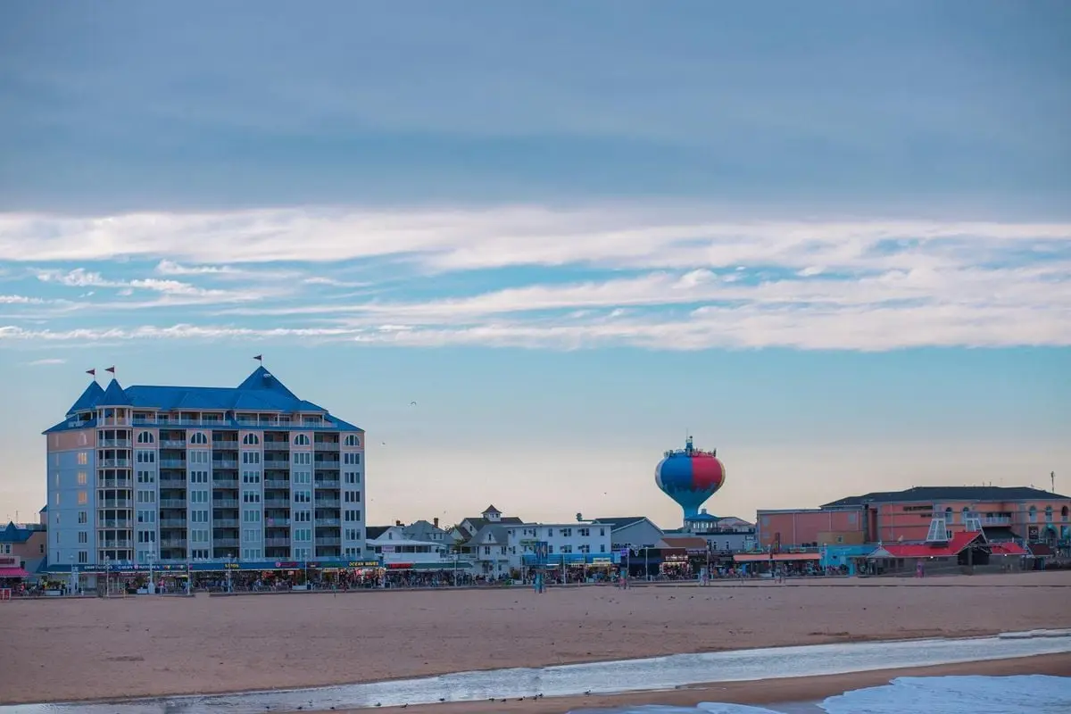 Scenic view of a beachfront with buildings and a colorful water tower, ideal for travel and tourism content.