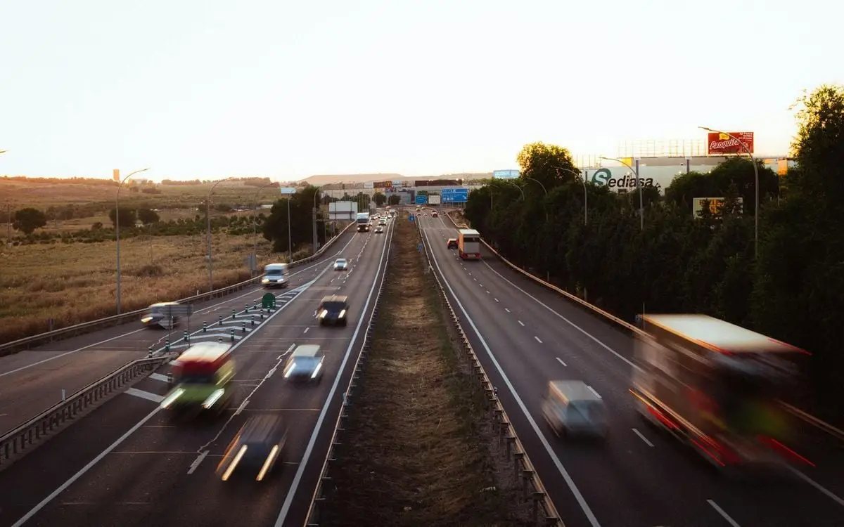 Aerial view of a busy multi-lane highway in Madrid, Spain during dusk, showcasing a dynamic travel scene.