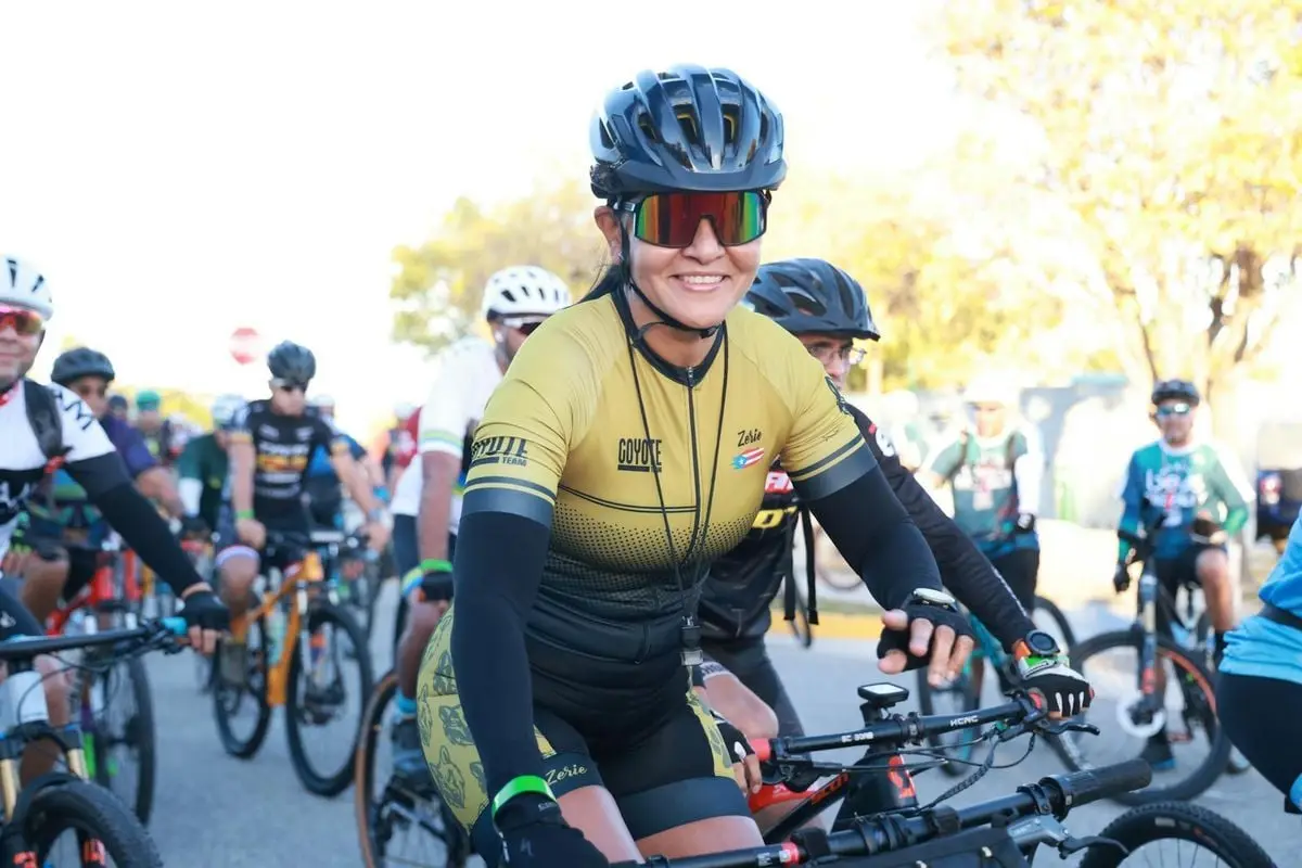 Cyclists gathered at an outdoor event, wearing helmets and gear, ready for a competition.