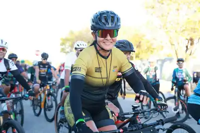 Cyclists gathered at an outdoor event, wearing helmets and gear, ready for a competition.