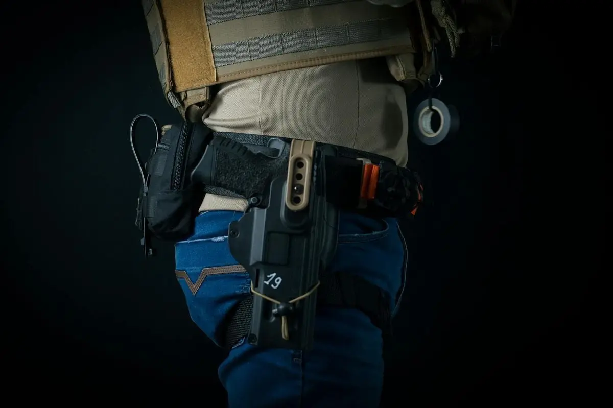 Close-up of tactical gear with holster, emphasizing safety and utility.