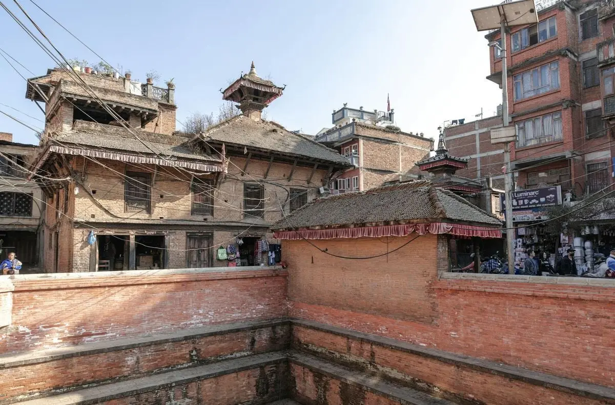 Historic brick buildings in Bhaktapur, Nepal's ancient cityscape under clear skies.